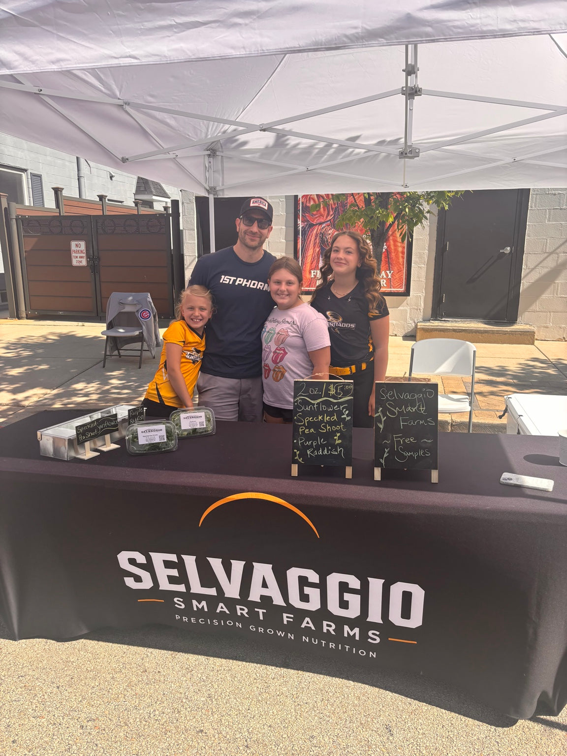 Tony Selvaggio with his three daughters at the Selvaggio Smart Farms farmers market booth